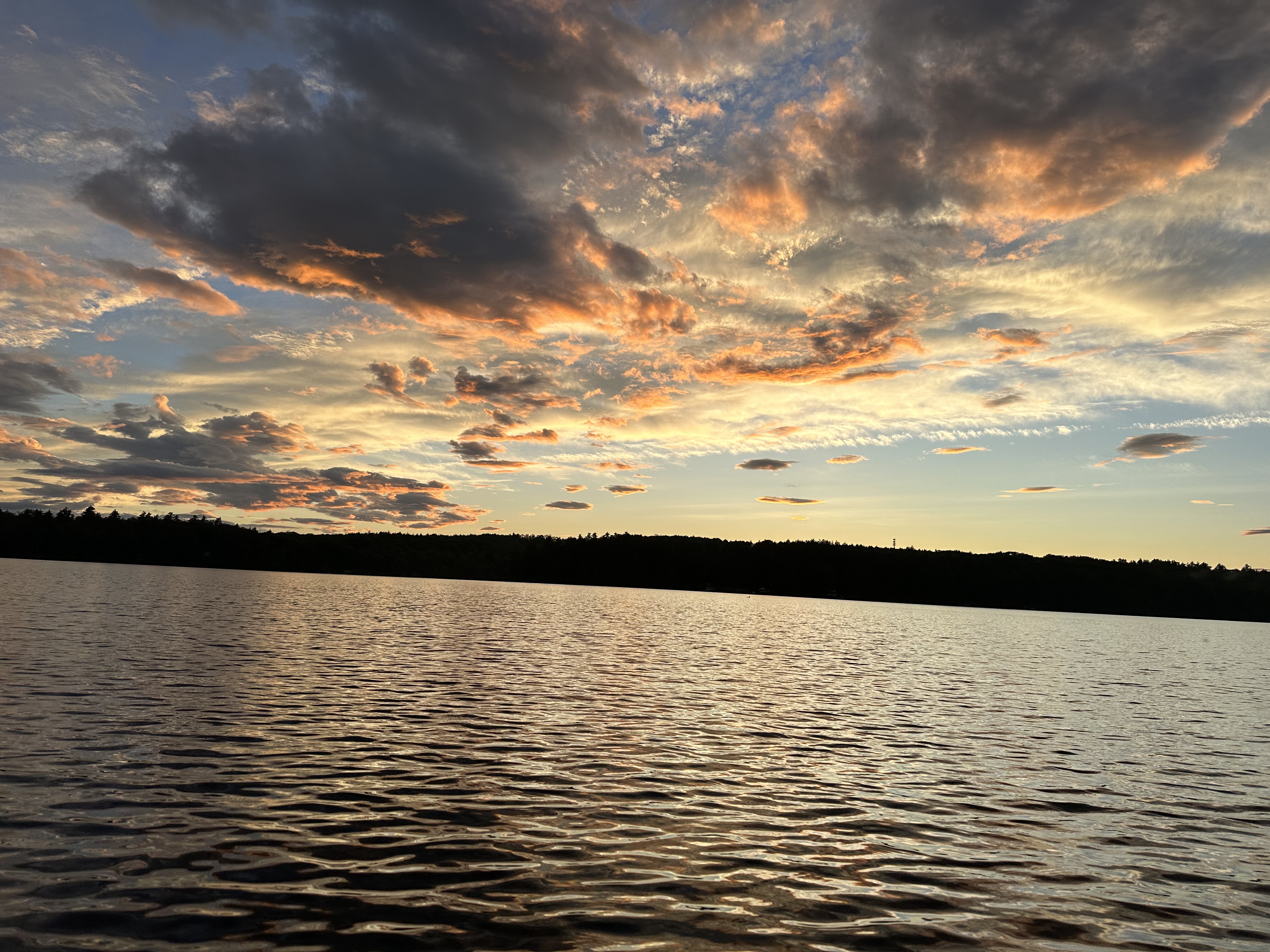 Golden sunset over the lake with glowing clouds